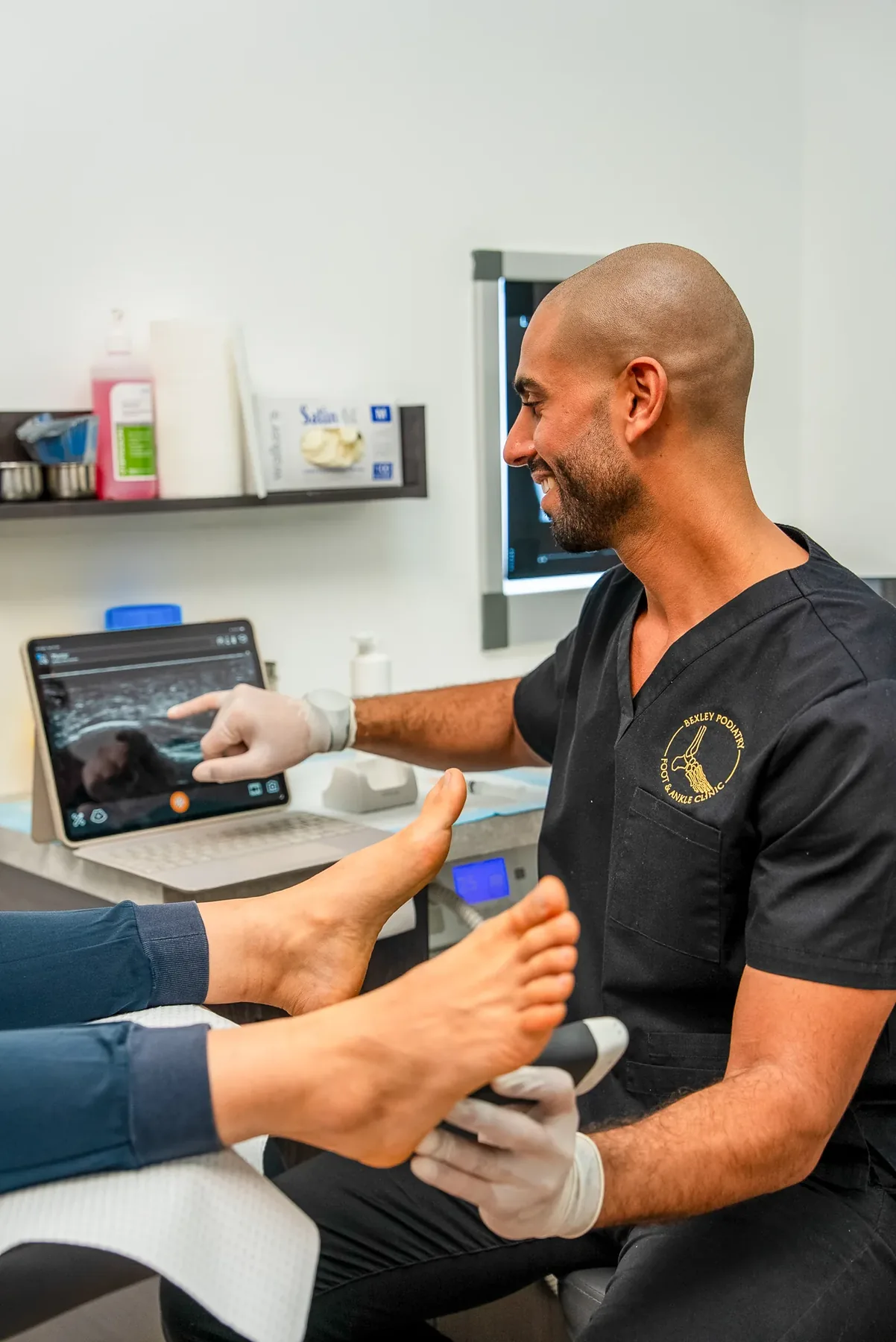 A podiatrist delivering shockwave therapy to a patient's lower limb at Bexley Podiatry: Foot & Ankle Clinic